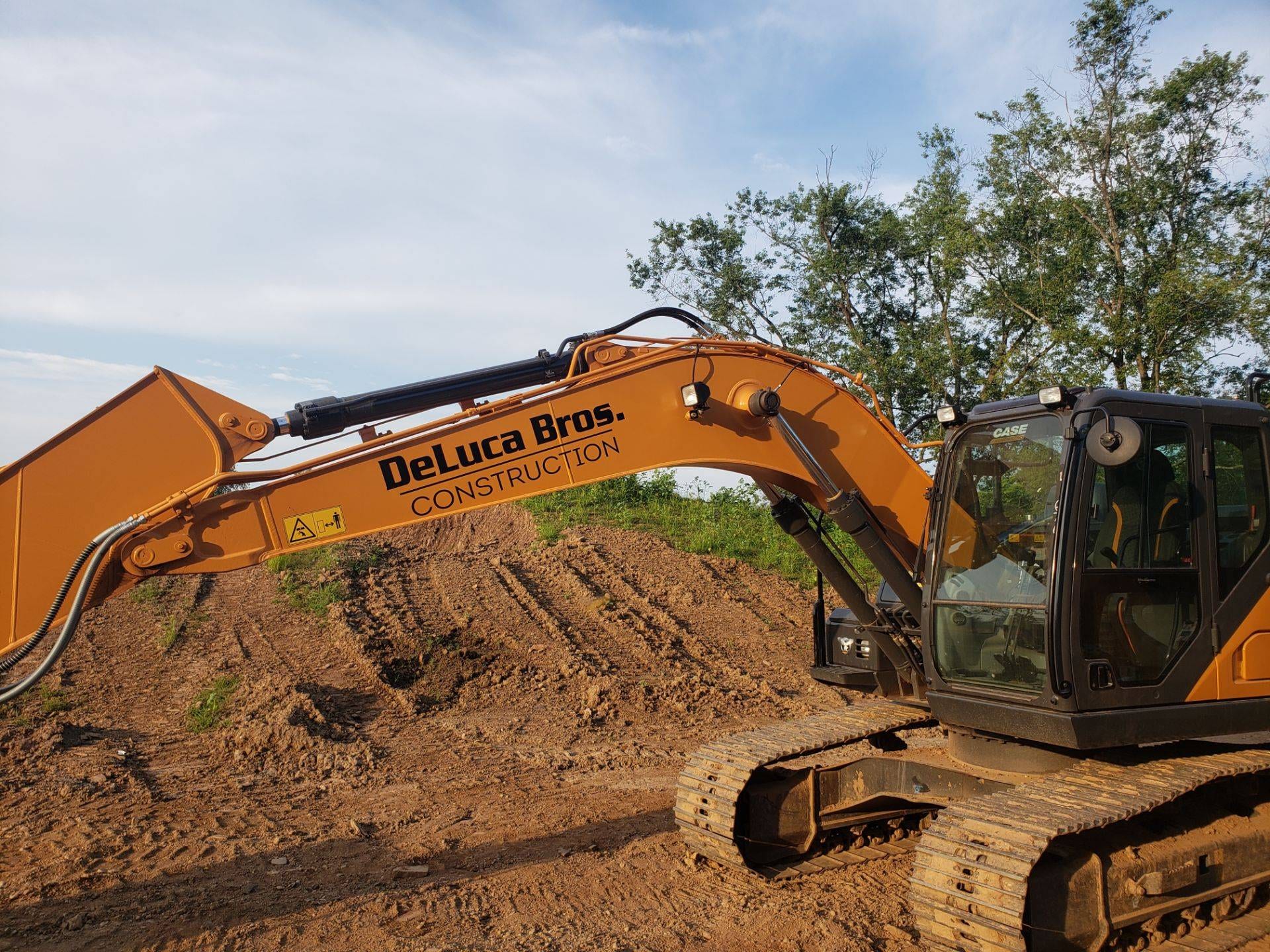 DeLuca Bros. Construction CASE excavator with the company name on the boom